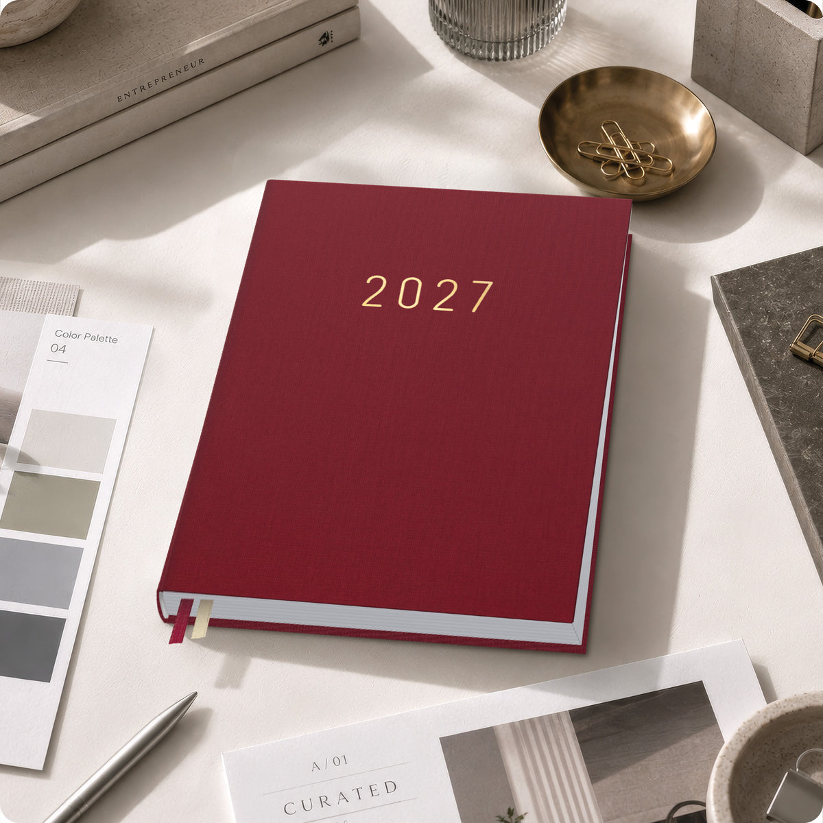 Lifestyle-Ansicht von Häfft Business-Timer Kalender 2027 A5 Wochenplaner im Motiv „Rubinrot“ im Einsatz.